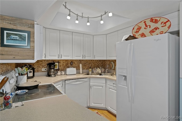 kitchen with white appliances, backsplash, white cabinets, sink, and light hardwood / wood-style flooring