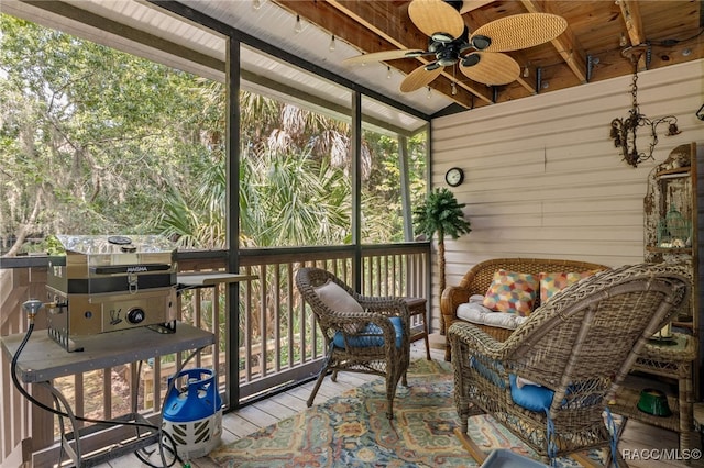 sunroom / solarium with ceiling fan, lofted ceiling with beams, and wood ceiling