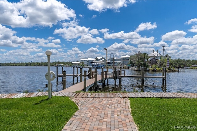 view of dock with a yard and a water view