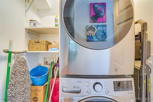 clothes washing area with stacked washer and dryer