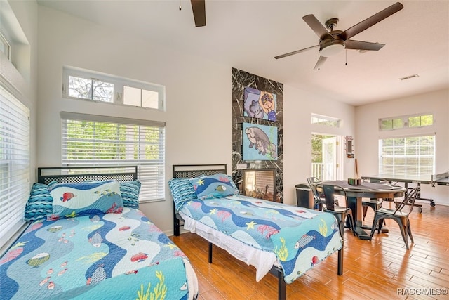 bedroom featuring ceiling fan, wood-type flooring, and multiple windows