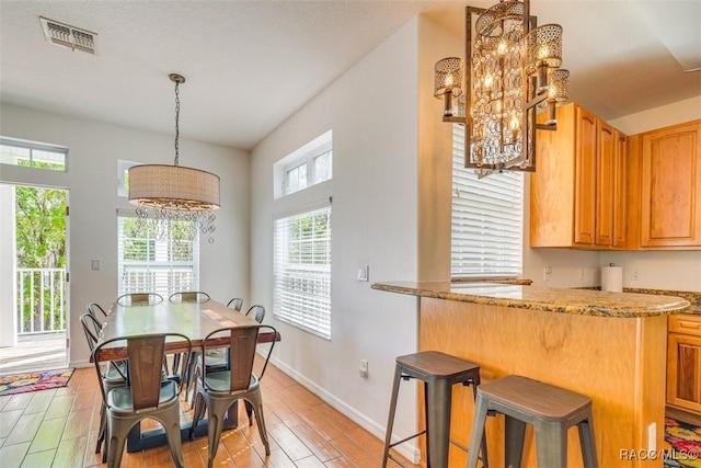 dining space featuring light hardwood / wood-style floors and an inviting chandelier