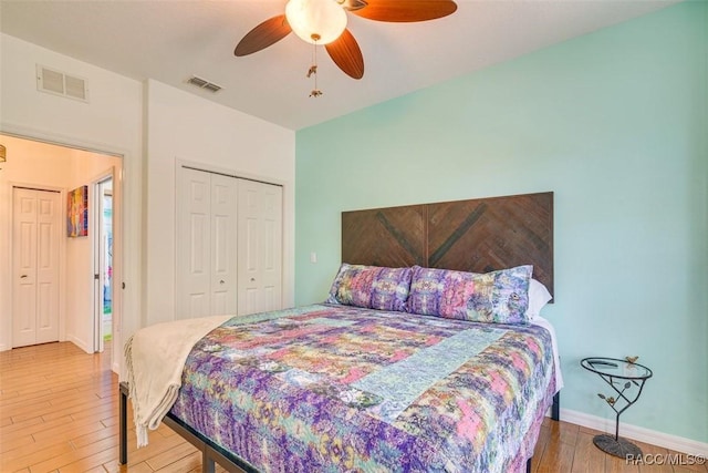 bedroom with ceiling fan, a closet, and wood-type flooring