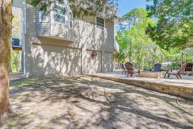 back of property featuring central air condition unit, a patio area, and a garage