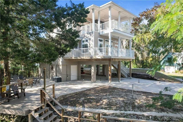 coastal inspired home featuring a balcony and a patio