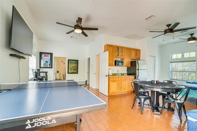 recreation room with ceiling fan and light hardwood / wood-style floors