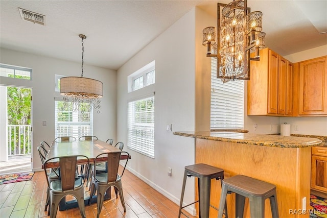 dining area featuring light hardwood / wood-style floors and a notable chandelier