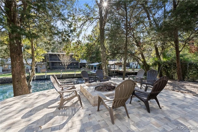 view of patio with a water view and a fire pit