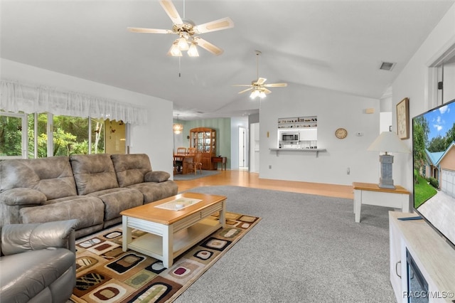 living room featuring ceiling fan, carpet, and vaulted ceiling