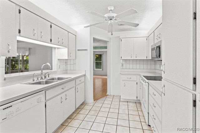 25 Redbay Ct W, Homosassa, FL 34446 - kitchen with white appliances, a sink, tasteful backsplash, a textured ceiling, and light countertops