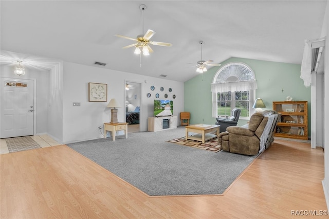 living room with ceiling fan, light wood-type flooring, and lofted ceiling