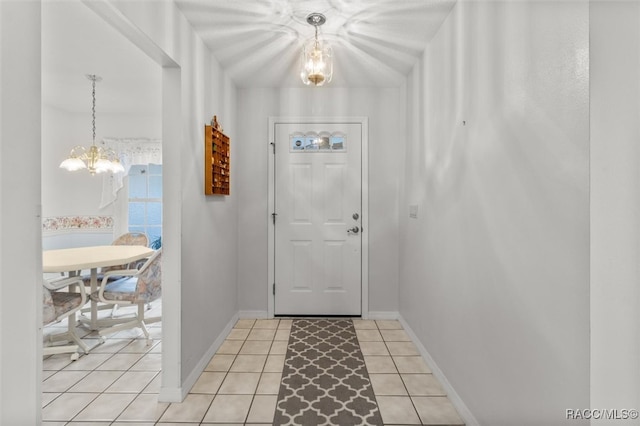 doorway to outside featuring an inviting chandelier and light tile patterned flooring