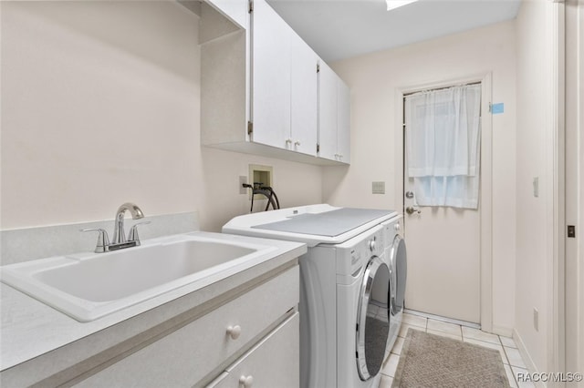 laundry room with cabinets, light tile patterned floors, washer and dryer, and sink