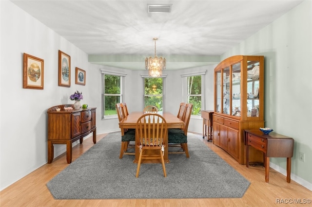 dining space featuring a wealth of natural light, light hardwood / wood-style flooring, and a chandelier