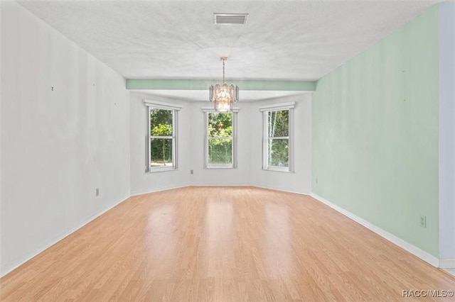 25 Redbay Ct W, Homosassa, FL 34446 - unfurnished room with a chandelier, wood finished floors, baseboards, and a textured ceiling