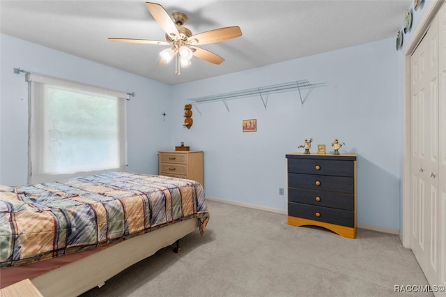 carpeted bedroom with ceiling fan and a closet