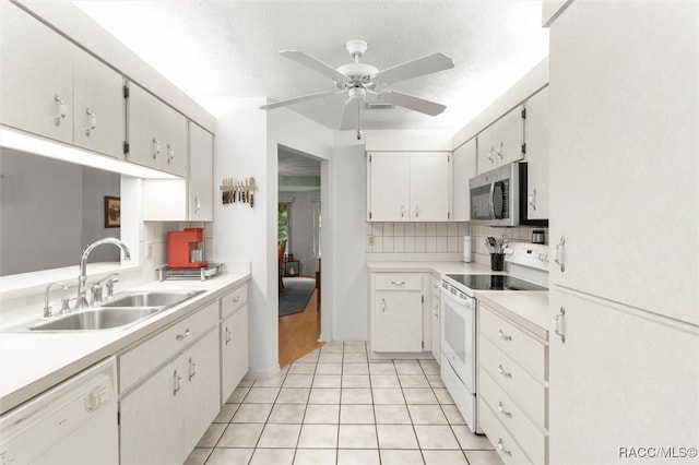 kitchen with white cabinets, white appliances, sink, and a textured ceiling