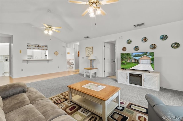 carpeted living room featuring vaulted ceiling and ceiling fan