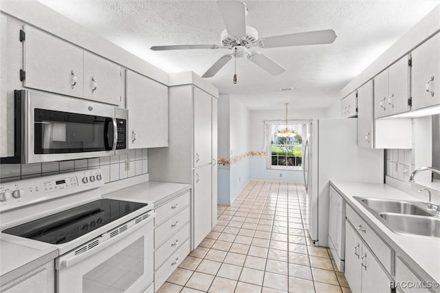 25 Redbay Ct W, Homosassa, FL 34446 - kitchen with white appliances, a sink, light countertops, ceiling fan, and a chandelier
