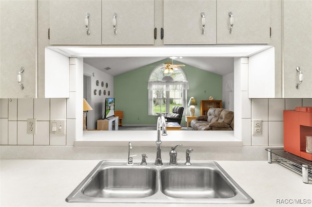 kitchen featuring backsplash, sink, and lofted ceiling