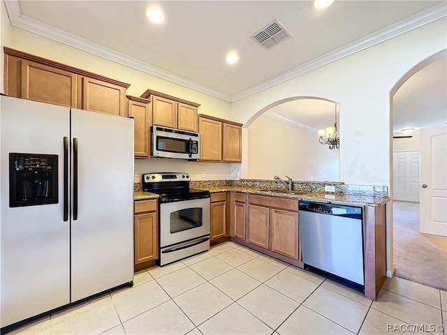 kitchen featuring crown molding, light colored carpet, a notable chandelier, and appliances with stainless steel finishes