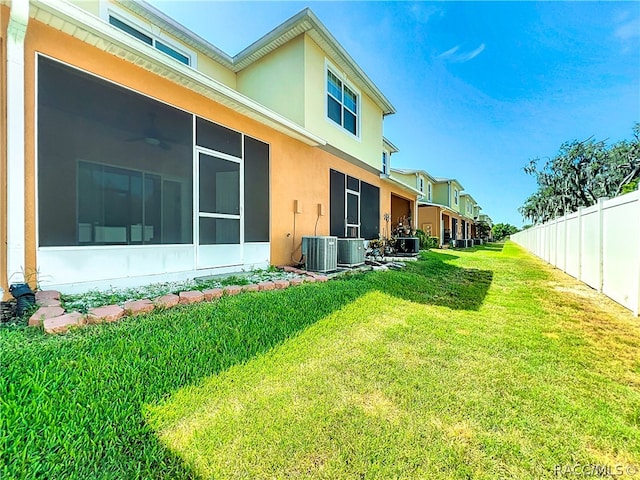 view of yard featuring a sunroom and central air condition unit