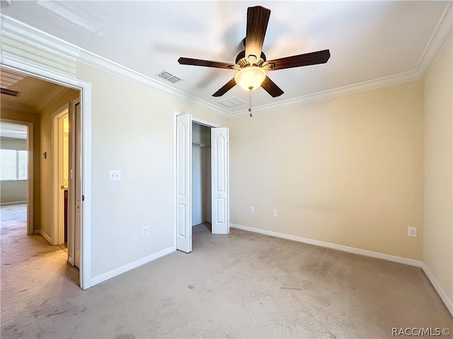 unfurnished bedroom featuring a closet, light colored carpet, ceiling fan, and crown molding