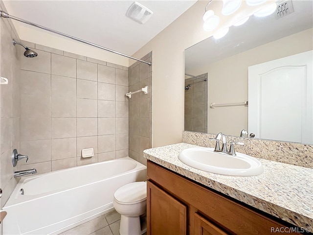 full bathroom featuring tile patterned floors, vanity, tiled shower / bath combo, and toilet