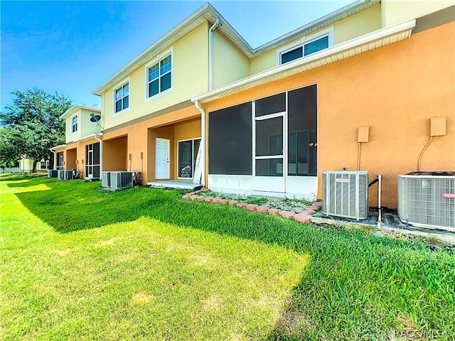 rear view of property with a lawn and central AC