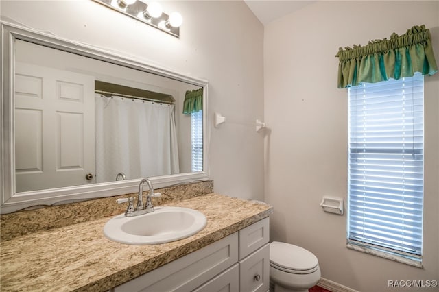 bathroom featuring curtained shower, vanity, and toilet