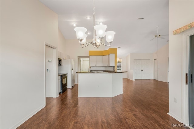 kitchen featuring dark countertops, dark wood-type flooring, open floor plan, white cabinetry, and black range with electric cooktop