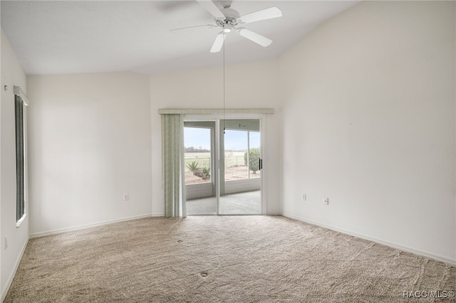 empty room with lofted ceiling, carpet floors, a ceiling fan, and baseboards