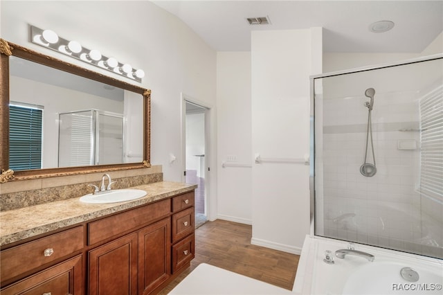 full bathroom featuring an enclosed shower, visible vents, wood finished floors, and vanity