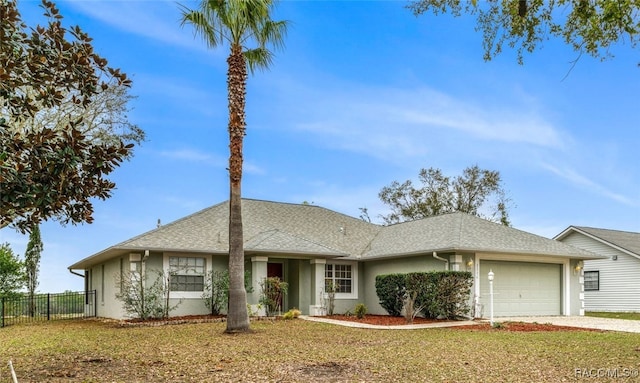 ranch-style home featuring a garage, driveway, a front yard, and fence