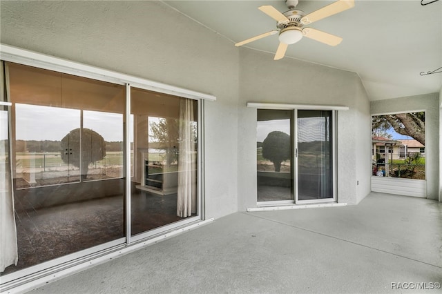 unfurnished sunroom with vaulted ceiling and ceiling fan