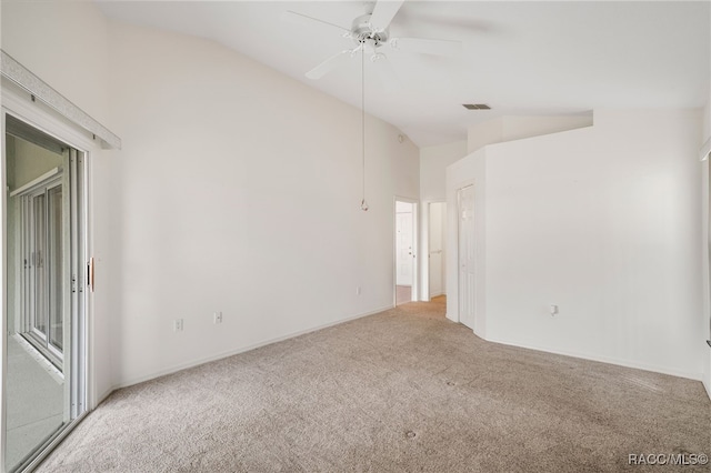 carpeted empty room with visible vents, vaulted ceiling, and a ceiling fan