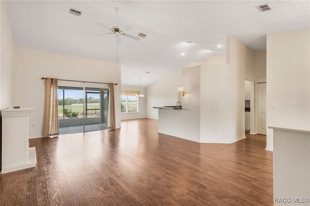 unfurnished living room with dark wood-type flooring, visible vents, high vaulted ceiling, and ceiling fan with notable chandelier