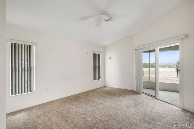 empty room with vaulted ceiling, carpet floors, and ceiling fan