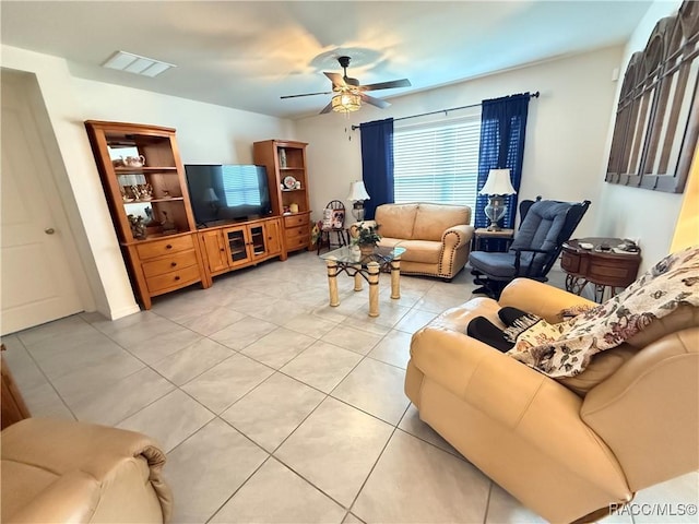 living room featuring light tile patterned floors, visible vents, and ceiling fan
