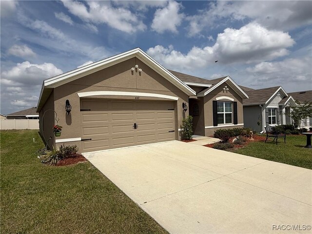 single story home featuring driveway, fence, a front yard, a garage, and stucco siding