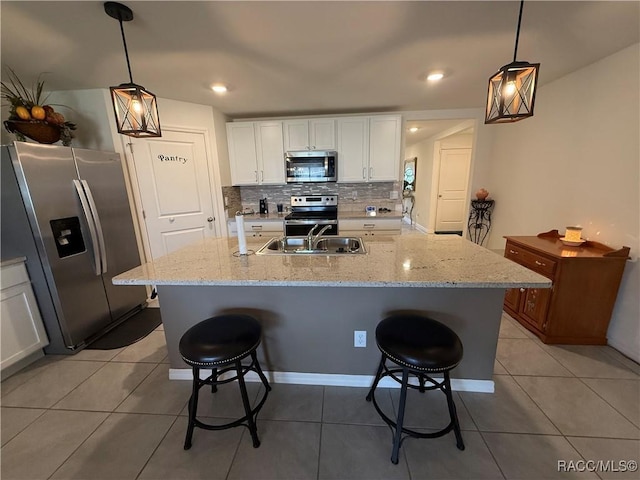 kitchen featuring a kitchen bar, decorative backsplash, stainless steel appliances, and a sink