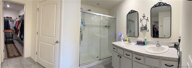 full bath featuring a shower stall, tile patterned floors, a sink, and double vanity