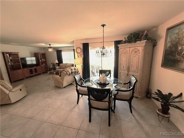 dining space featuring light tile patterned flooring and ceiling fan with notable chandelier