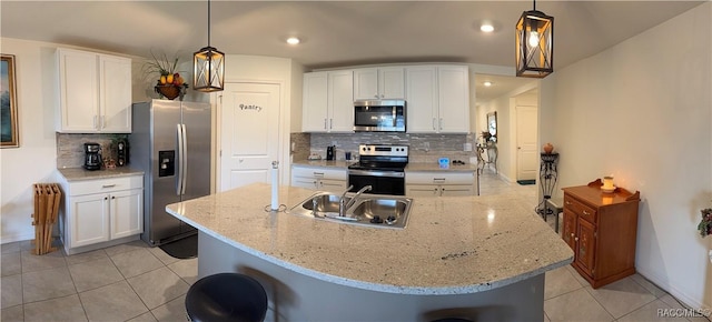 kitchen with light tile patterned flooring, tasteful backsplash, stainless steel appliances, and a sink