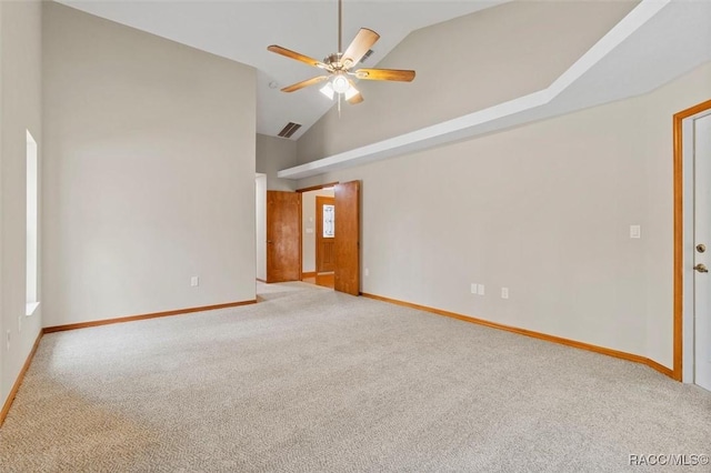 carpeted spare room with ceiling fan and high vaulted ceiling