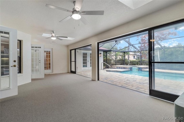 unfurnished living room featuring carpet, a textured ceiling, and ceiling fan