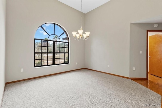 carpeted empty room featuring a chandelier