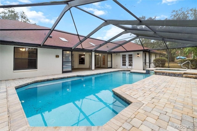 view of swimming pool with a lanai, an in ground hot tub, french doors, and a patio