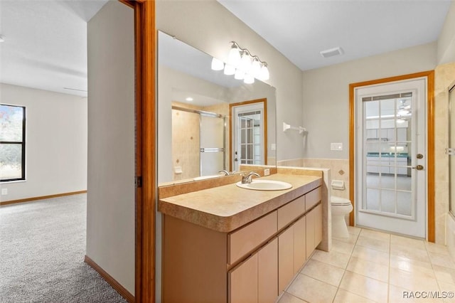 bathroom with tile patterned flooring, vanity, toilet, and walk in shower