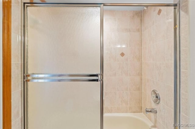 bathroom featuring bath / shower combo with glass door